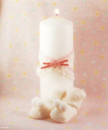 شمع روشن در کنار پاپوش نوزاد